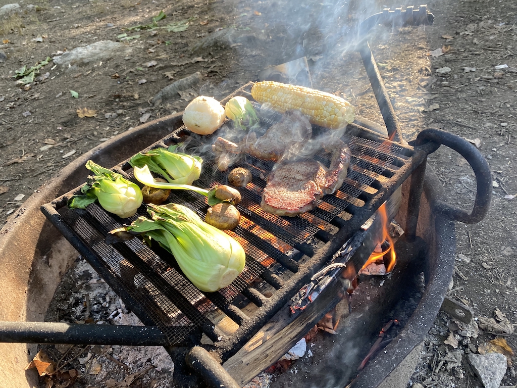 キャンプの美味しいお肉、とうもろこし、おにぎり、野菜